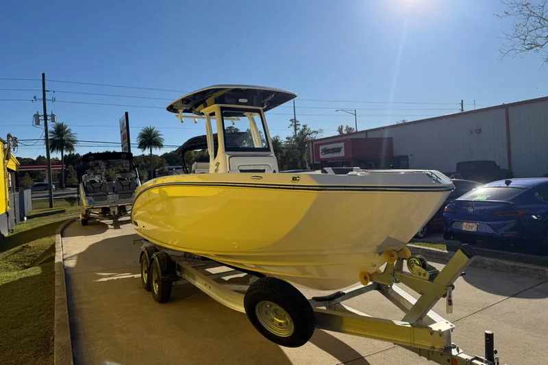 Slide: The Image of 2026 Yamaha Boats 252 FSH Sport in yellow on trailer, sunny day. - 7