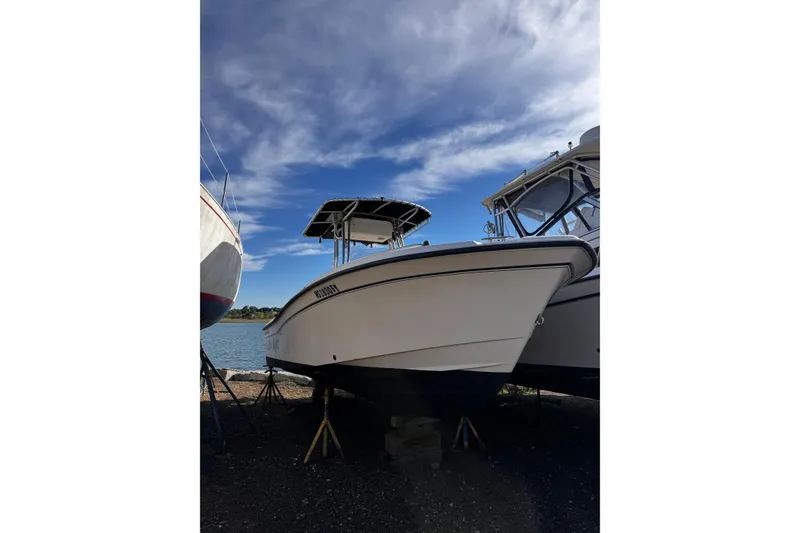 The Image of 1999 Grady-White Fisherman 222 boat on stands by the water under a blue sky. - 0