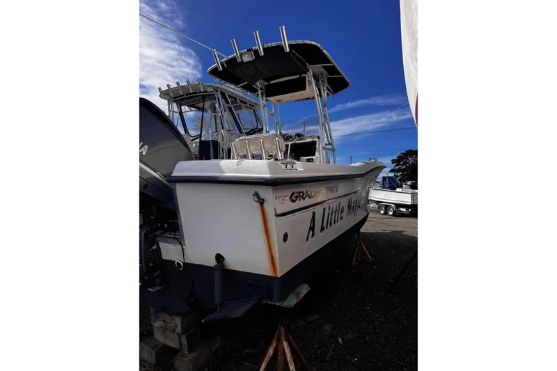 Slide: The Image of 1999 Grady-White Fisherman 222 boat on land, featuring a sturdy hull and T-top. - 11