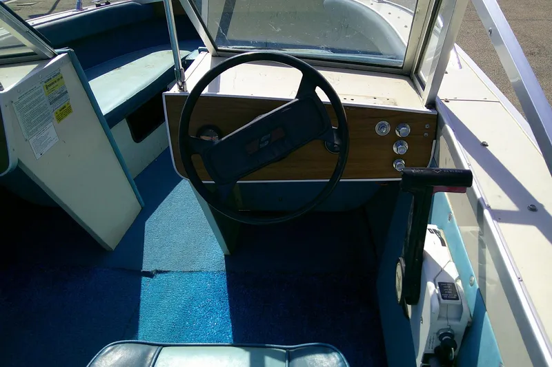 Slide: The Image of Interior of a 1981 Starcraft SuperSport 160 boat with steering wheel and controls. - 12