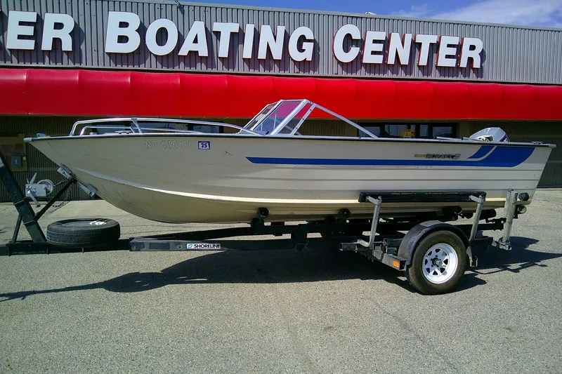 Slide: The Image of 1981 Starcraft SuperSport 160 boat on trailer outside boating center. - 3