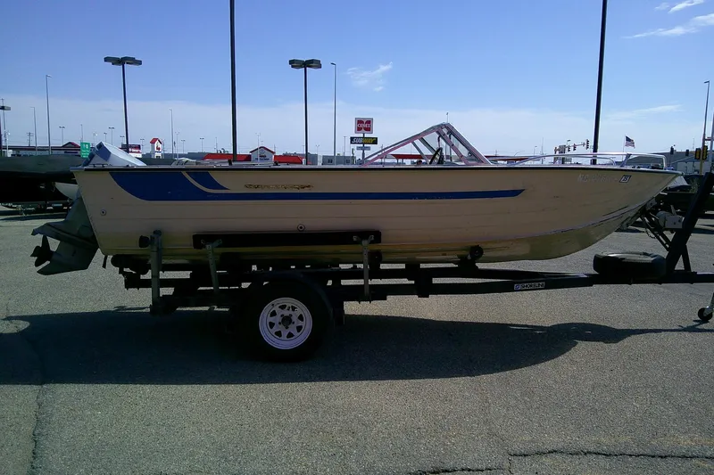 Slide: The Image of 1981 Starcraft SuperSport 160 boat on trailer in parking lot under clear sky. - 5
