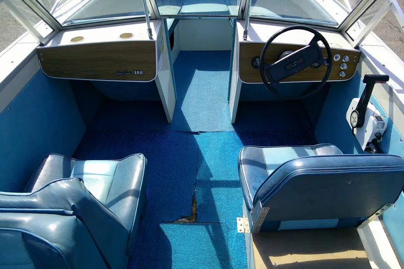 Slide: The Image of Interior of a 1981 Starcraft SuperSport 160 boat with blue seating and steering wheel. - 7