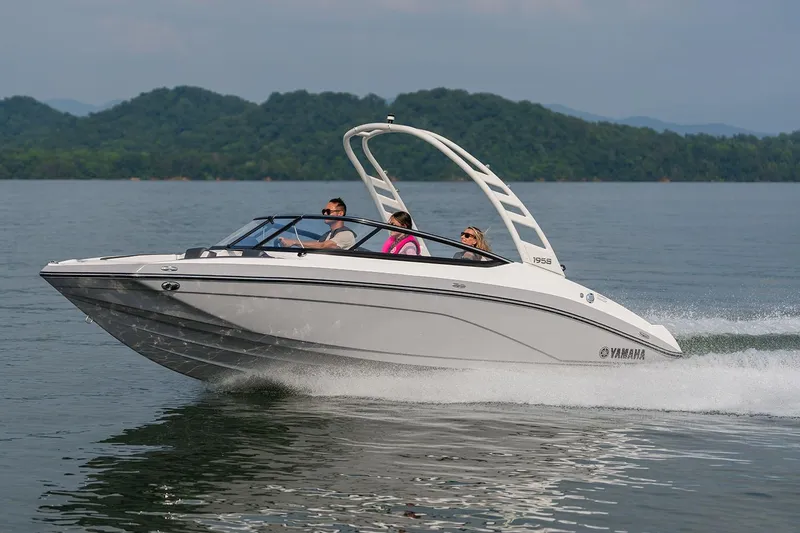 Slide: The Image of Manufacturer Provided Image: 2026 Yamaha Boats 195S cruising on a lake with passengers, scenic mountain backdrop. - 7
