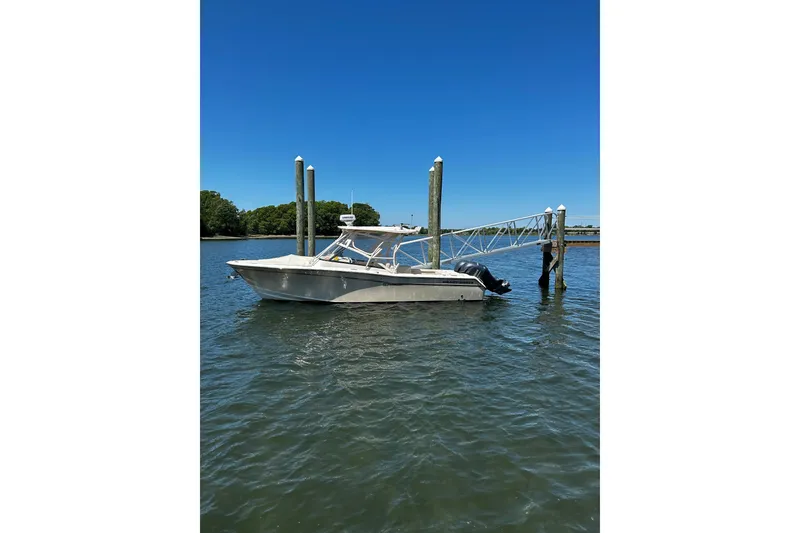 The Image of 2016 Grady-White Freedom 275 boat docked on calm water under clear blue sky. - 0