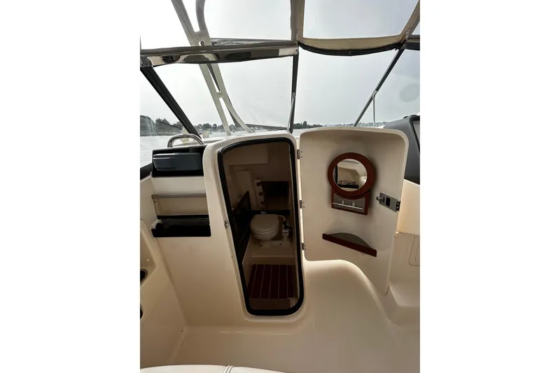 Slide: The Image of 2016 Grady-White Freedom 275 boat interior with open cabin door and visible toilet. - 5