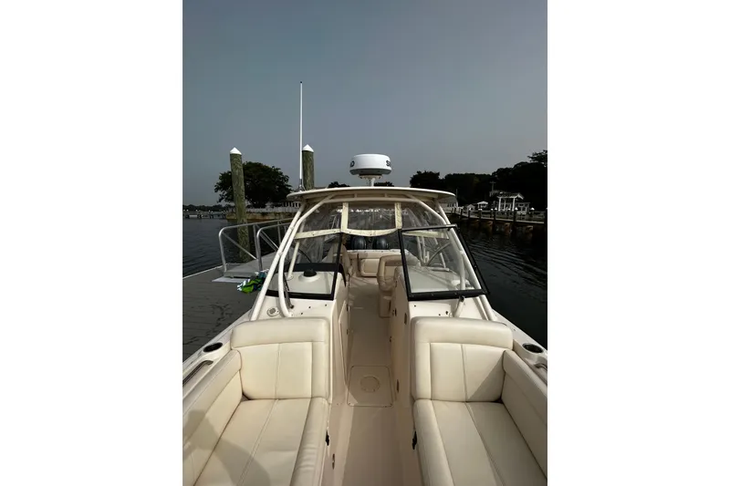 Slide: The Image of 2016 Grady-White Freedom 275 boat docked, featuring spacious seating and sleek design. - 6