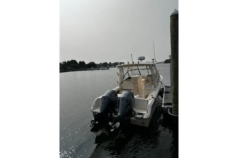 Slide: The Image of 2016 Grady-White Freedom 275 boat docked on calm water. - 7