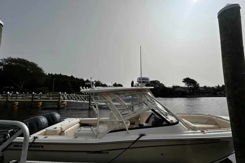 Slide: The Image of 2016 Grady-White Freedom 275 boat docked by a serene waterfront. - 8
