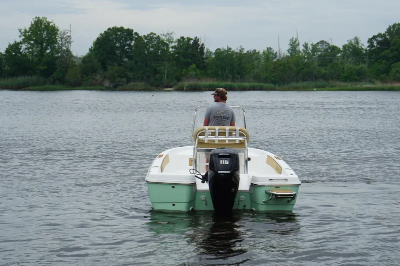 Slide: The Image of Man steering a 2025 Savannah 190 IS boat on a calm river. - 5