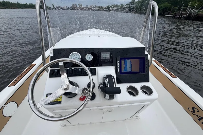 Slide: The Image of 2025 Savannah 190 IS boat dashboard with steering wheel and navigation system on a river. - 7
