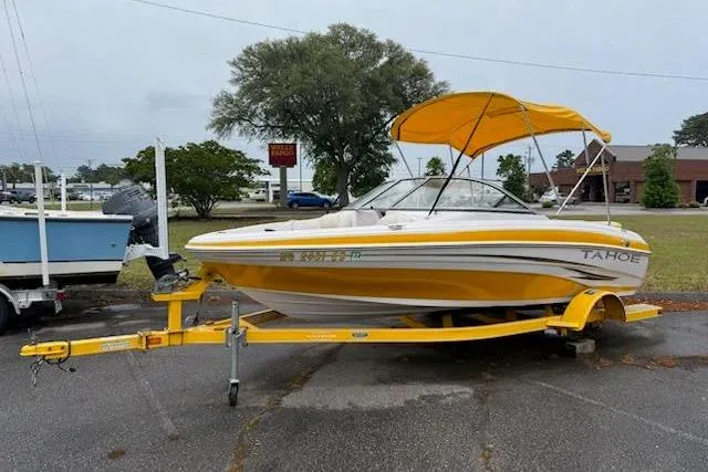 The Image of 2008 Tahoe Q4 SF boat with yellow canopy on trailer in parking lot. - 1