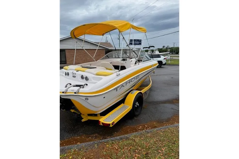 Slide: The Image of 2008 Tahoe Q4 SF boat with yellow canopy and trailer, parked outdoors. - 2