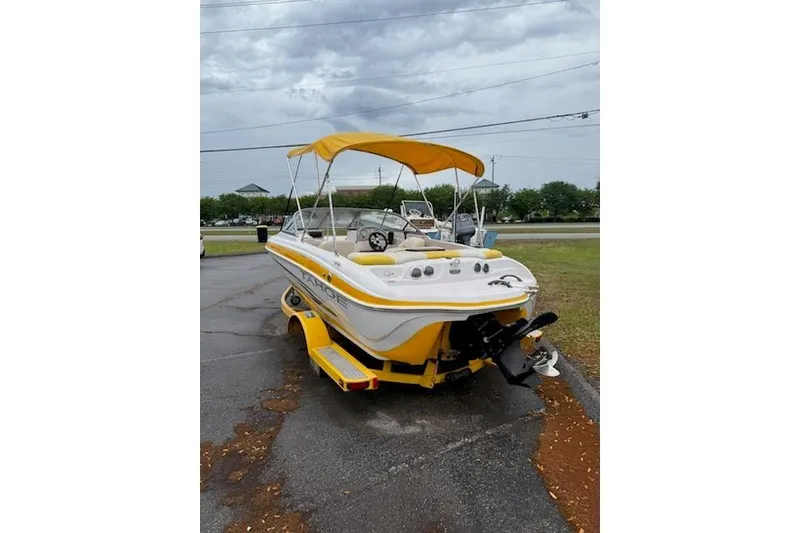 Slide: The Image of 2008 Tahoe Q4 SF boat with yellow canopy on a trailer, parked outdoors. - 4