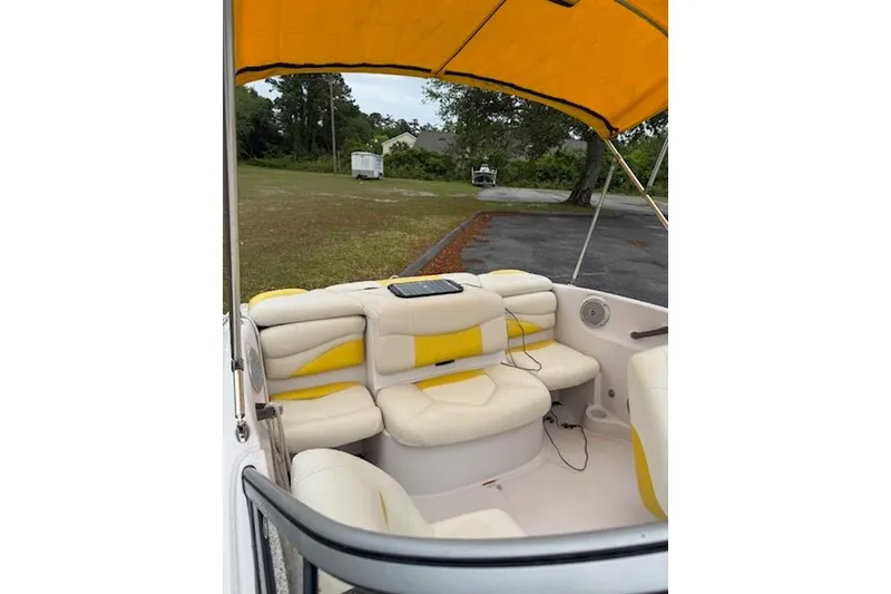 Slide: The Image of 2008 Tahoe Q4 SF boat interior with yellow and white seating under canopy. - 6