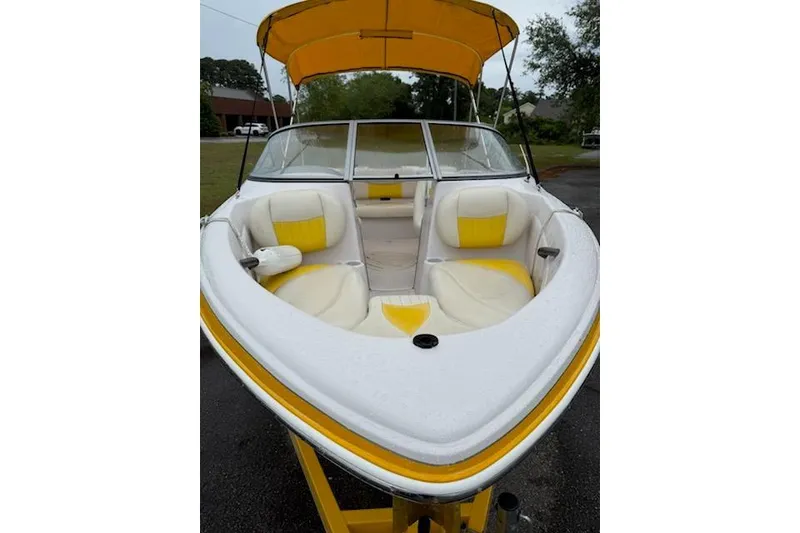 Slide: The Image of 2008 Tahoe Q4 SF boat with yellow and white interior, parked outdoors. - 7