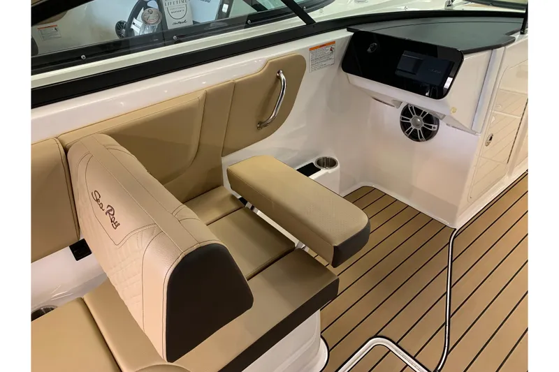 Slide: The Image of Luxurious interior of 2025 Sea Ray SDX 270 boat with tan seating and sleek dashboard. - 11