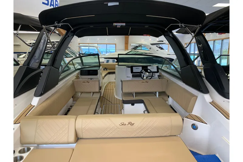 Slide: The Image of 2025 Sea Ray SDX 270 boat interior with beige seating and modern dashboard. - 2