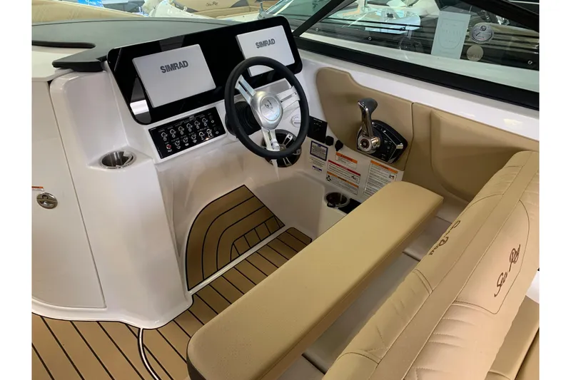 Slide: The Image of 2025 Sea Ray SDX 270 boat cockpit with Simrad displays and beige seating. - 8