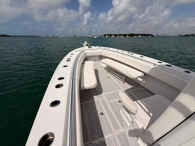 Slide: The Image of Contender 27 Tournament boat, 2001, on calm waters with sailboats in the background. - 9