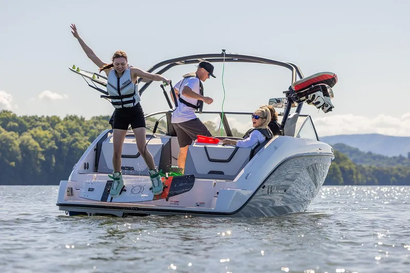 Slide: The Image of Manufacturer Provided Image: 2026 Yamaha Boats AR220 on lake with people enjoying water activities. - 14