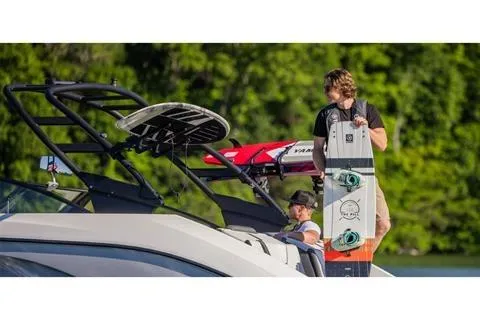 Slide: The Image of 2026 Yamaha Boats AR220 with wakeboards, set against a lush green backdrop. - 16