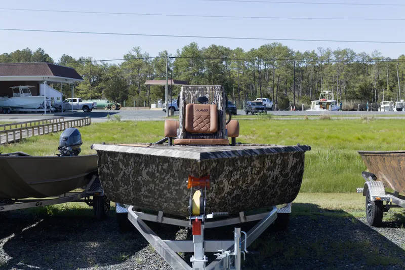 Slide: The Image of 2026 Avid 20 Rogue CC boat on trailer, camo design, parked outdoors. - 3