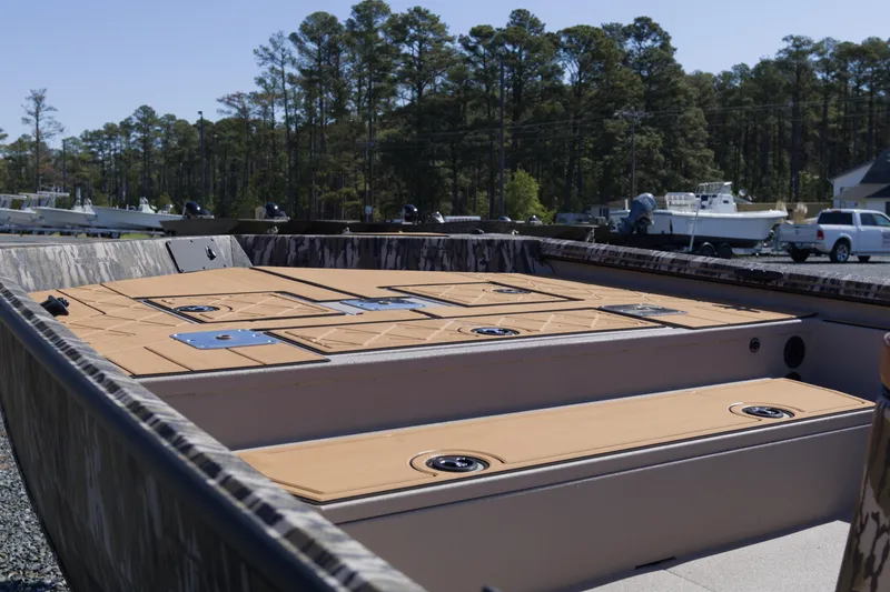 Slide: The Image of Avid 20 Rogue CC 2026 boat interior with deck storage, parked outdoors. - 8