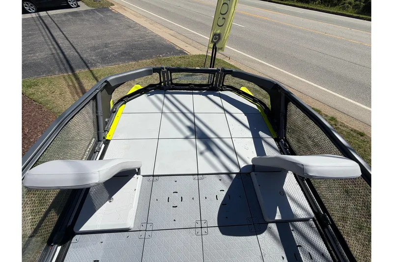 Slide: The Image of 2024 Sea-Doo Switch Sport 21 deck with seating, parked near a road. - 6