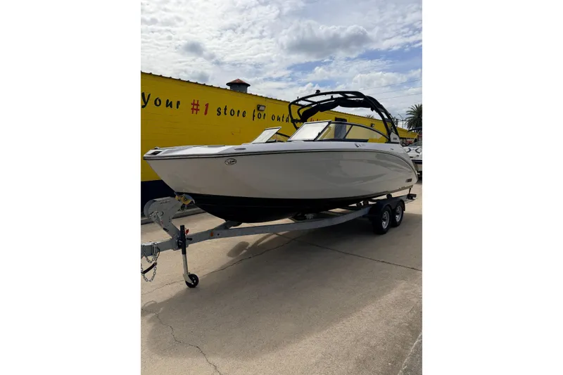 The Image of 2026 Yamaha Boats 252S on trailer, parked outdoors under cloudy sky. - 0