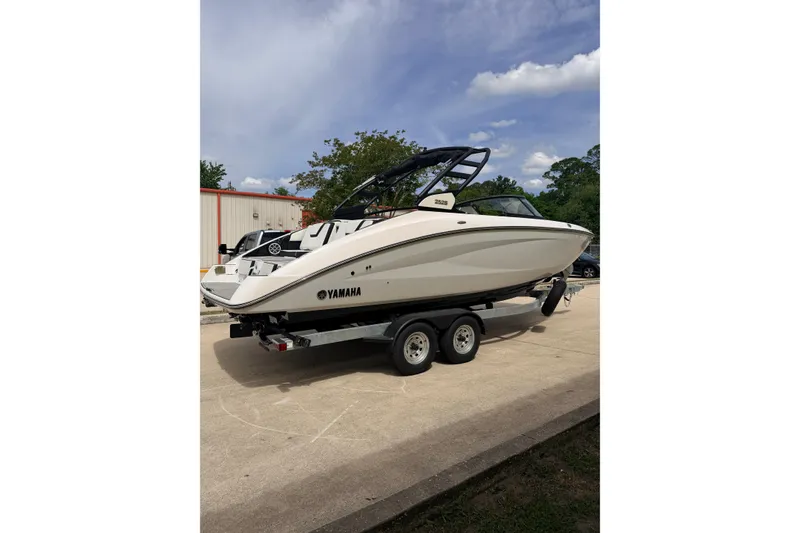 Slide: The Image of 2026 Yamaha Boats 252S on trailer, parked outdoors under a clear sky. - 4