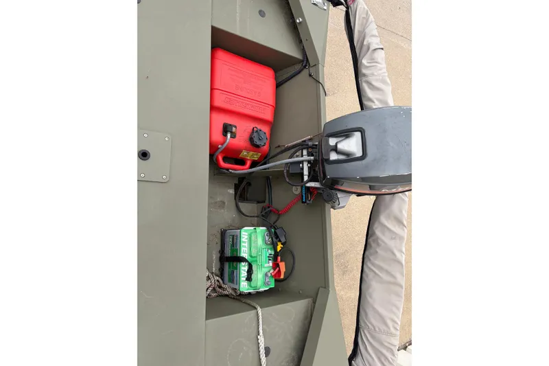 Slide: The Image of 2024 Tracker Marine Grizzly 1754 boat interior with motor, battery, and fuel tank. - 11