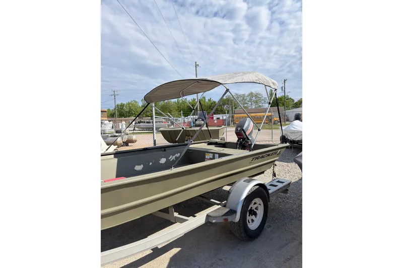 Slide: The Image of 2024 TRACKER MARINE Grizzly 1754 boat with canopy on trailer, parked outdoors. - 5