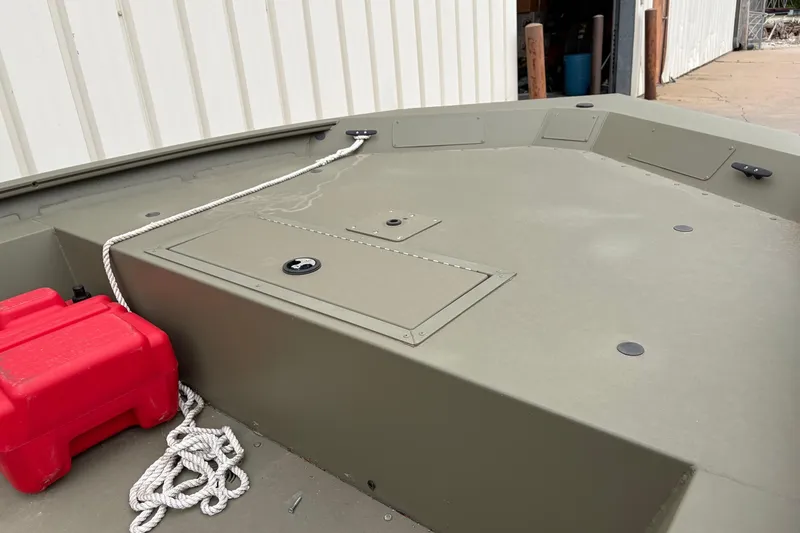 Slide: The Image of 2024 TRACKER MARINE Grizzly 1754 boat deck with storage compartments and red fuel tank. - 8