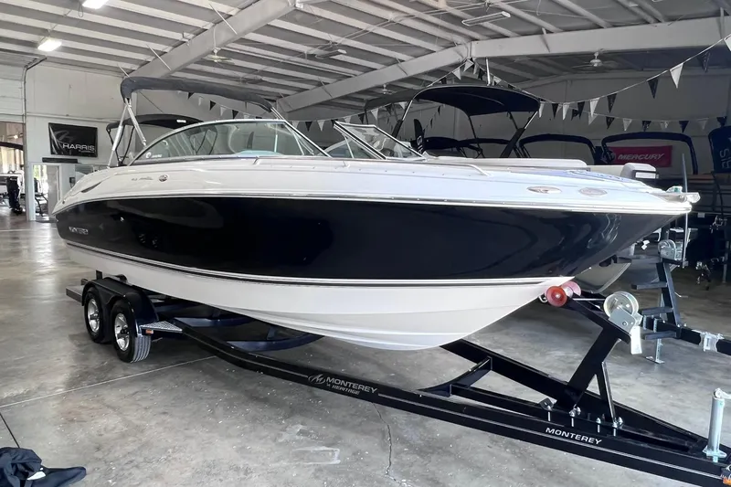Slide: The Image of 2007 Monterey 248LS Montura Bowrider on trailer in showroom, sleek black and white design. - 3