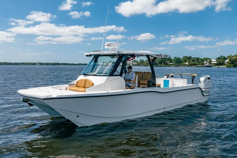 Slide: The Image of 2026 MVI Invicta 30OC boat cruising on a sunny day, featuring sleek design and modern amenities. - 8