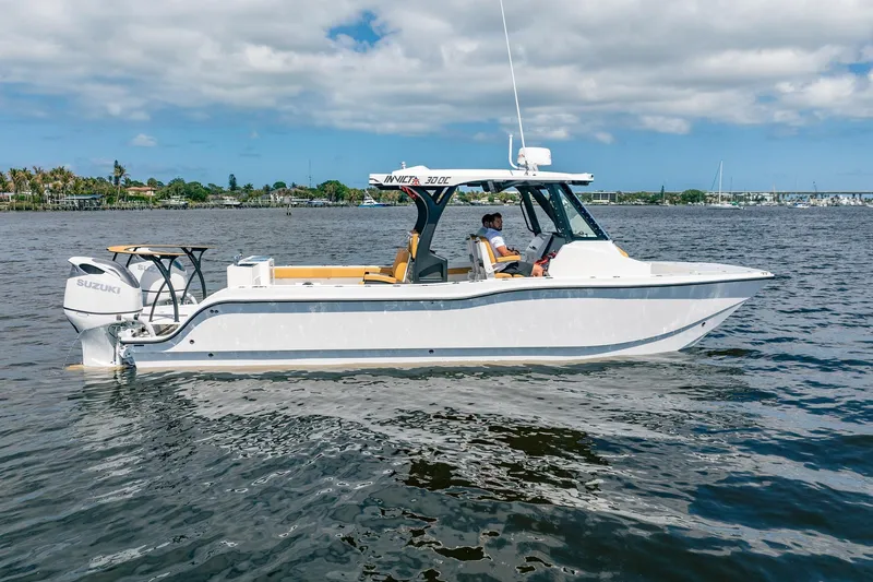 The Image of 2026 MVI Invicta 30OC boat on water, featuring Suzuki engine, clear sky background. - 4