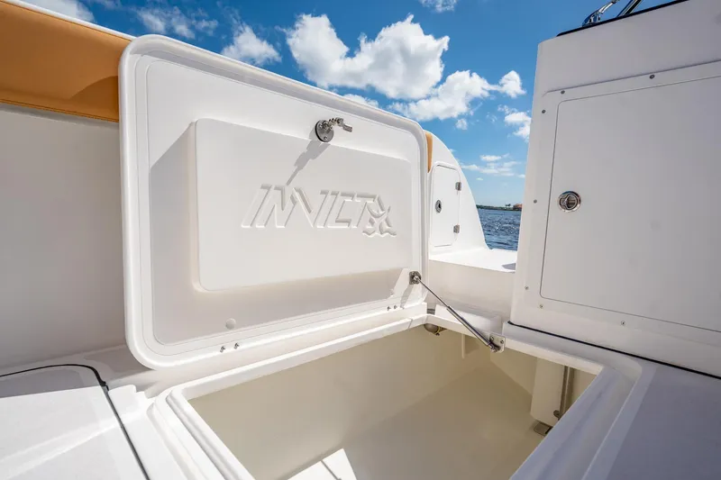 Slide: The Image of Open storage compartment on 2026 MVI Invicta 30OC boat under a clear blue sky. - 21