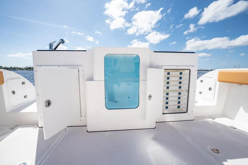 Slide: The Image of 2026 MVI Invicta 30OC boat deck with storage compartments and clear blue panel. - 15