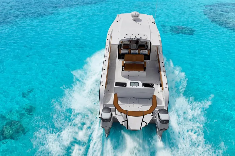 Slide: The Image of MVI Invicta 30OC boat cruising on clear turquoise water, 2026 model. - 2
