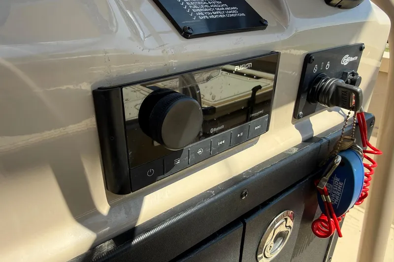 Slide: The Image of Control panel of 2022 G3 Bay 18 GX boat with audio system and safety lanyard. - 16