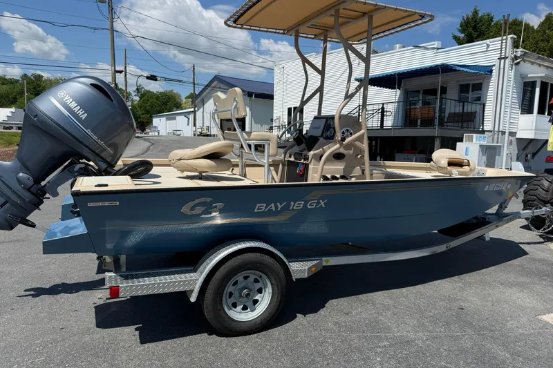 Slide: The Image of 2022 G3 Bay 18 GX boat with Yamaha motor on trailer, parked outdoors. - 5