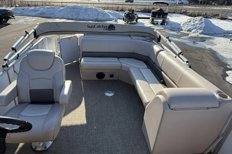 Slide: The Image of 2019 SunCatcher V322 Cruise pontoon boat interior with plush seating and steering wheel. - 18