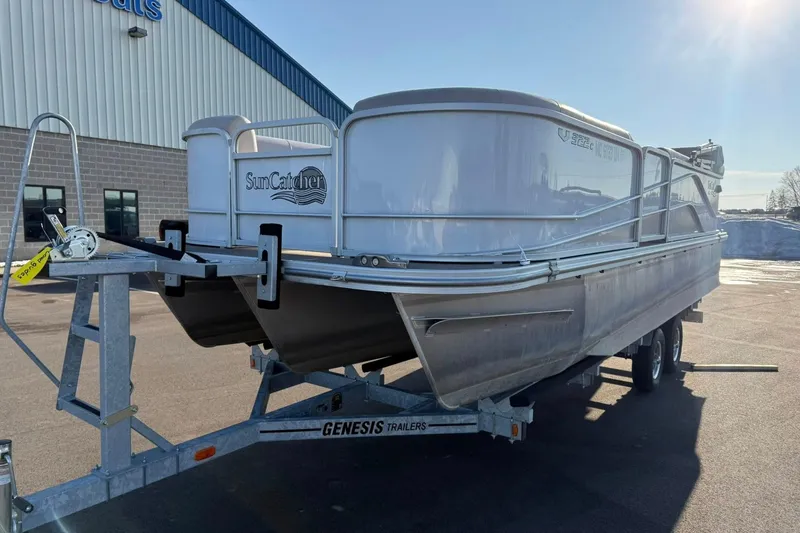 Slide: The Image of 2019 SunCatcher V322 Cruise pontoon boat on Genesis trailer, parked outside a building. - 2