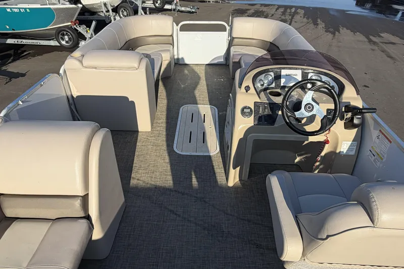 Slide: The Image of 2019 SunCatcher V322 Cruise pontoon boat interior with beige seating and steering console. - 20