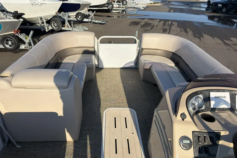 Slide: The Image of 2019 SunCatcher V322 Cruise pontoon boat interior with beige seating and control panel. - 24