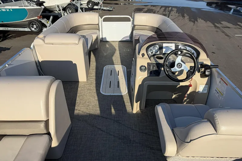 Slide: The Image of 2019 SunCatcher V322 Cruise pontoon boat interior with beige seating and steering console. - 25