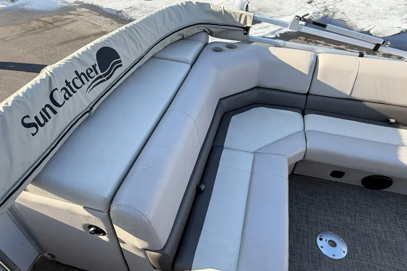 Slide: The Image of 2019 SunCatcher V322 Cruise boat interior with gray seating and cup holders. - 34