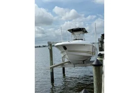 The Image of 2001 Scarab boat docked on lift over water under cloudy sky. - 1
