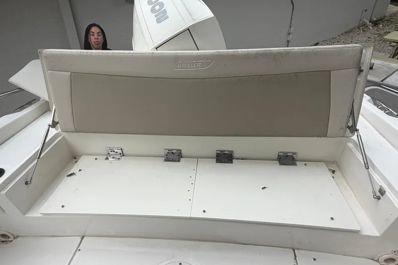 Slide: The Image of 2019 Boston Whaler 210 Dauntless boat seat with storage compartment, slightly weathered. - 19